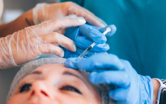 An injector guided through a forehead injection by an experienced practitioner, the kind of hands-on training and shadowing we introduce